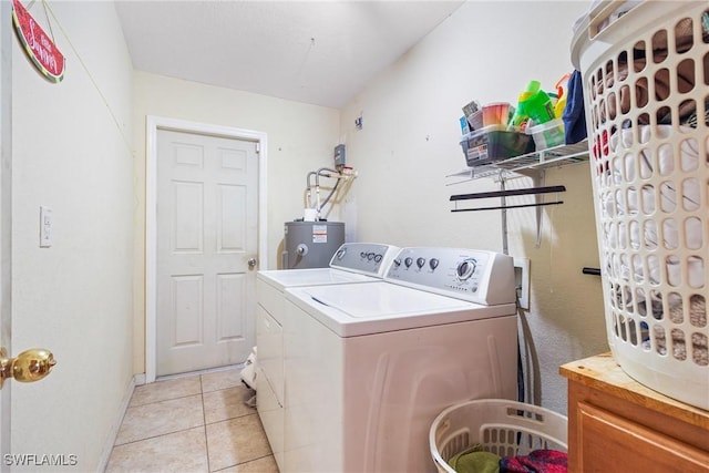 clothes washing area with gas water heater, washing machine and dryer, and light tile patterned floors