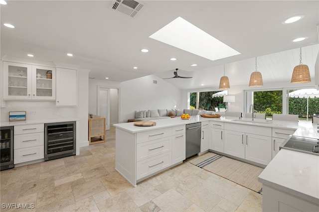 kitchen featuring a sink, stone tile flooring, visible vents, stainless steel dishwasher, and beverage cooler