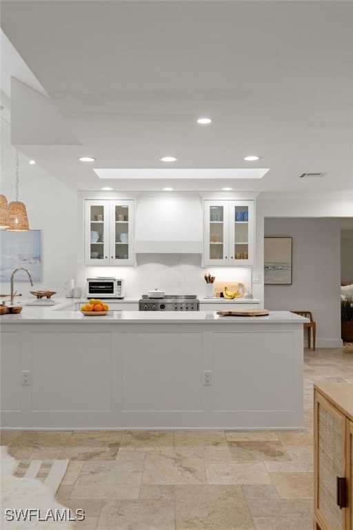 kitchen featuring range, a sink, white cabinets, and light countertops