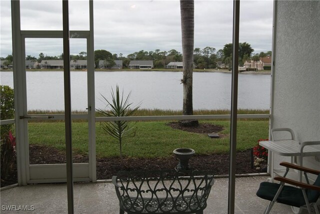 sunroom / solarium featuring a water view