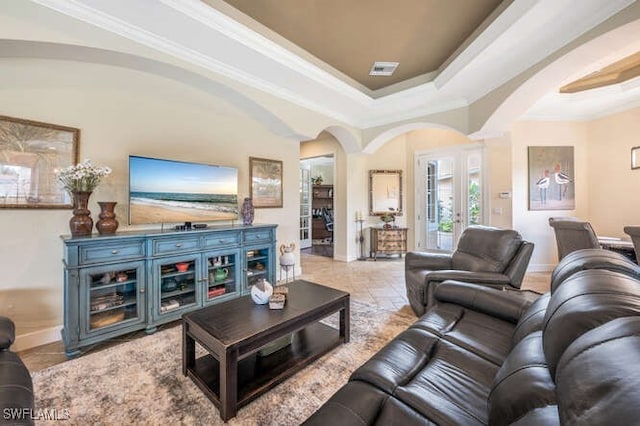 living room with a raised ceiling and crown molding