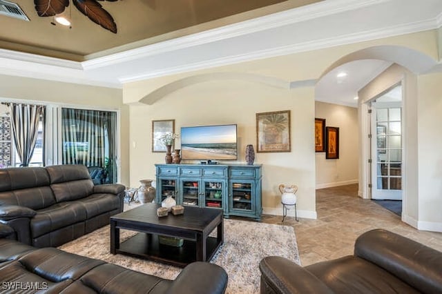 living room with a raised ceiling and crown molding