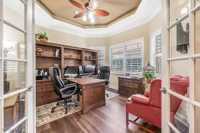 home office with french doors, ornamental molding, dark wood-type flooring, ceiling fan, and a tray ceiling