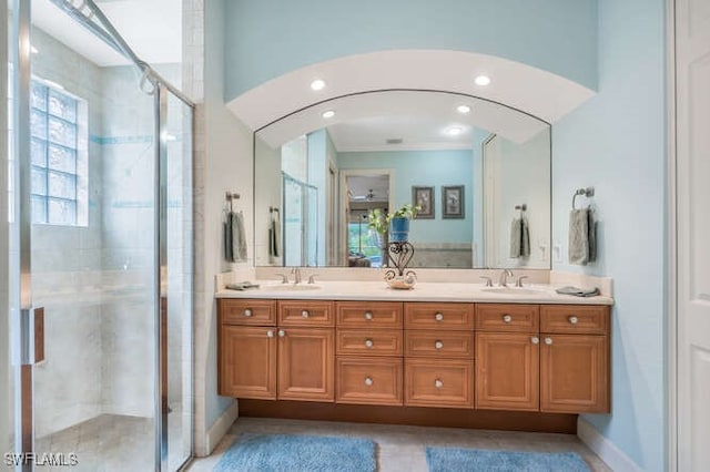 bathroom with ornamental molding, a shower with shower door, and vanity