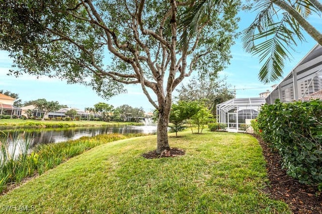 view of yard featuring glass enclosure and a water view