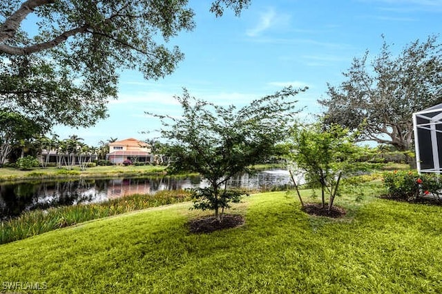 view of yard featuring glass enclosure and a water view