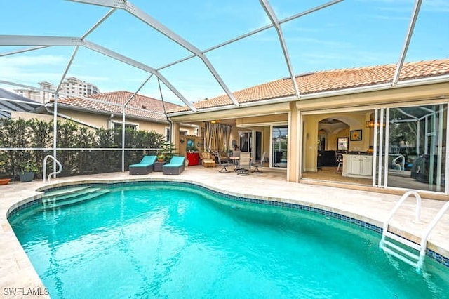 view of swimming pool featuring a patio area and a lanai