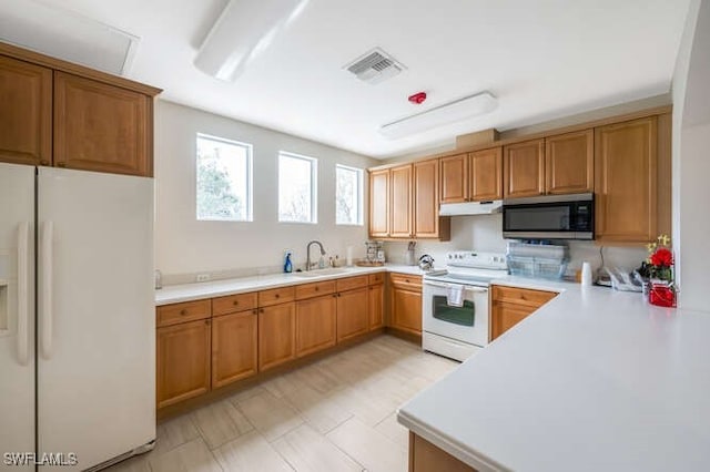 kitchen with sink, white appliances, and kitchen peninsula