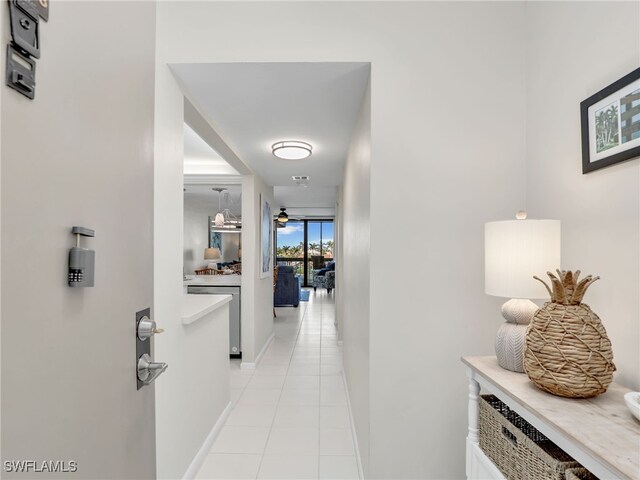 hall with floor to ceiling windows and light tile patterned floors