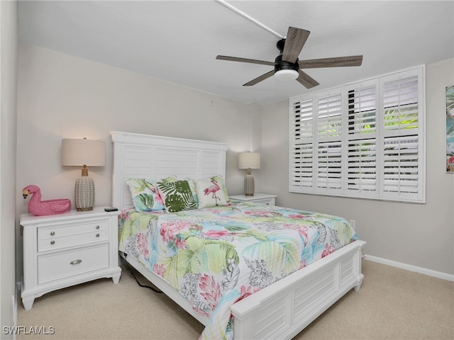 bedroom featuring a ceiling fan, light colored carpet, and baseboards