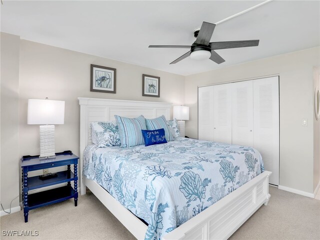 carpeted bedroom with ceiling fan and a closet