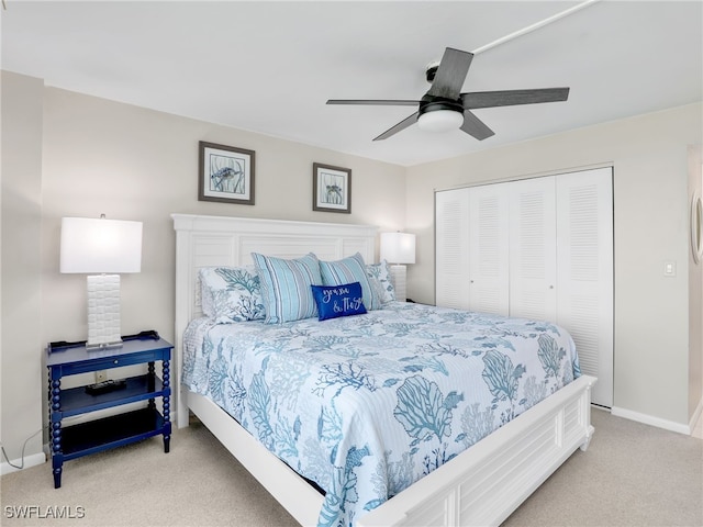 bedroom with ceiling fan, baseboards, a closet, and light colored carpet