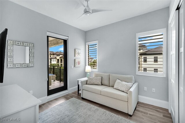 living room with wood-type flooring and ceiling fan