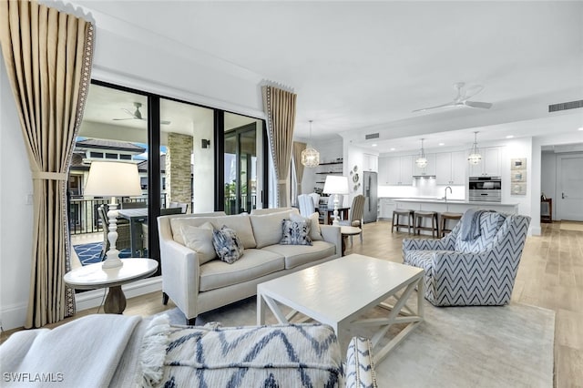 living room featuring ceiling fan and light hardwood / wood-style floors