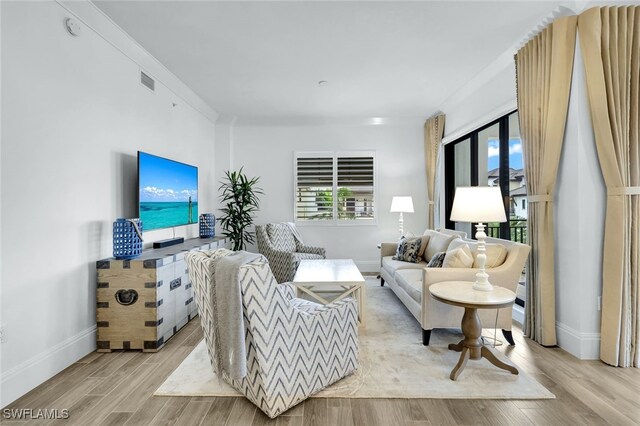 living room featuring ornamental molding and light wood-type flooring