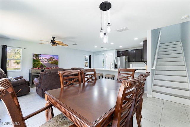 dining area with sink, ceiling fan, and light tile patterned flooring