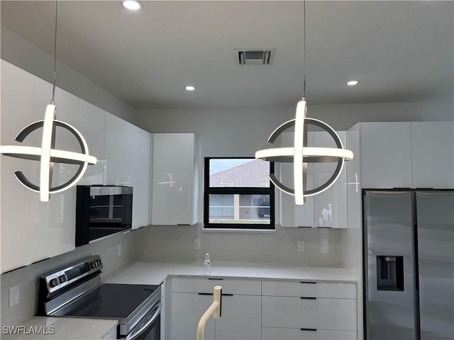 kitchen with backsplash, decorative light fixtures, stainless steel appliances, and white cabinets