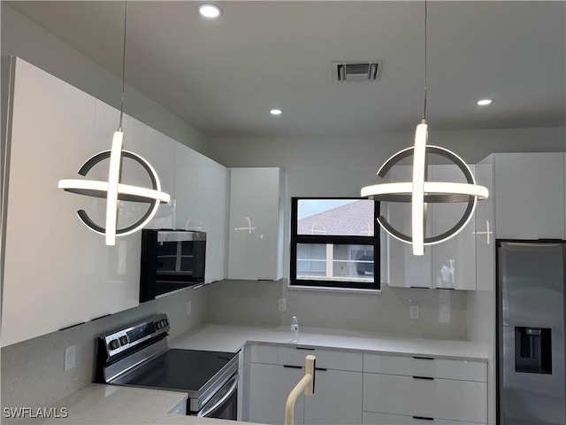 kitchen featuring white cabinetry, appliances with stainless steel finishes, backsplash, and pendant lighting