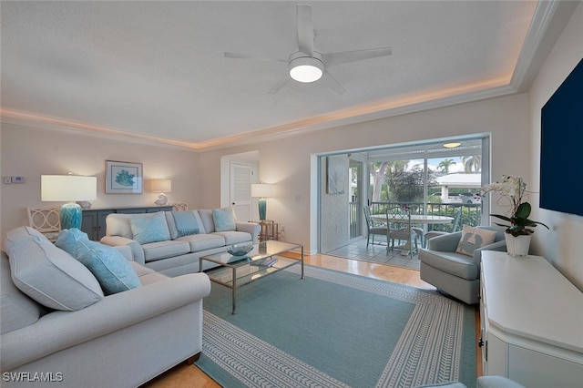 living room featuring ceiling fan, ornamental molding, light tile patterned floors, and a textured ceiling