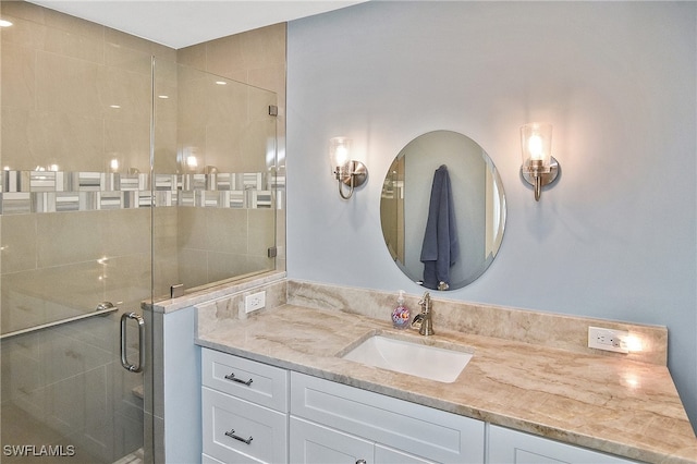 bathroom with a shower with door and vanity