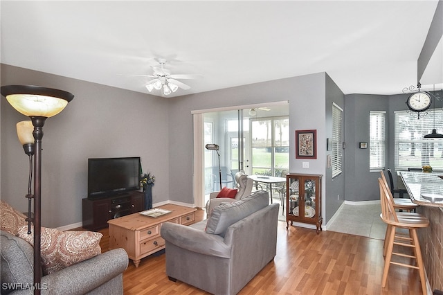 living room with ceiling fan and light hardwood / wood-style flooring