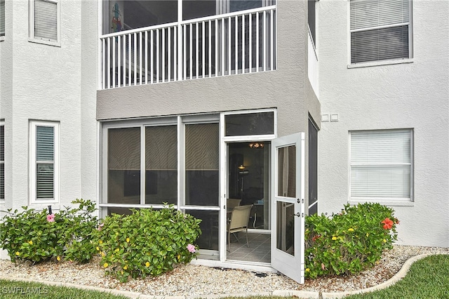 view of exterior entry featuring a balcony