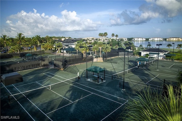 view of tennis court with a water view