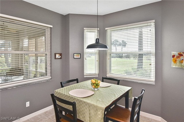 dining area with light tile patterned flooring, a wealth of natural light, and baseboards