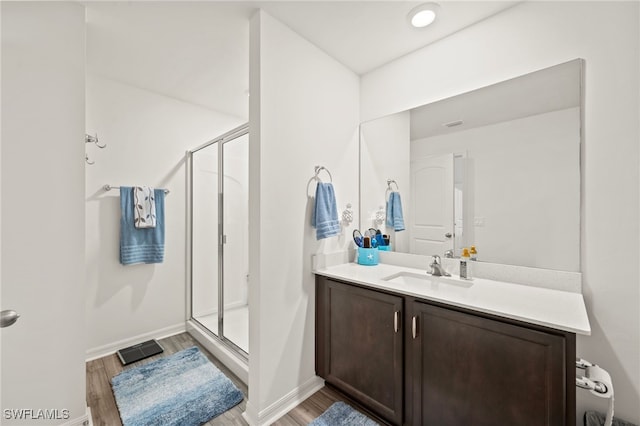 bathroom with vanity, hardwood / wood-style floors, and a shower with door