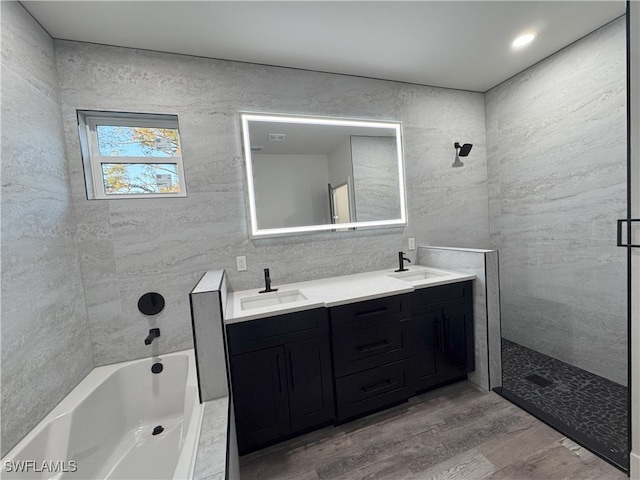 bathroom featuring wood-type flooring, vanity, and tile walls