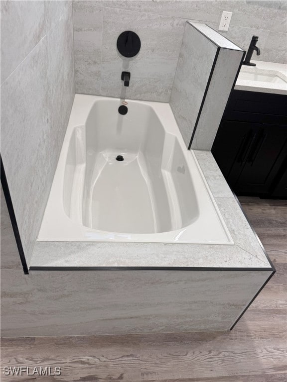 bathroom featuring vanity and a washtub