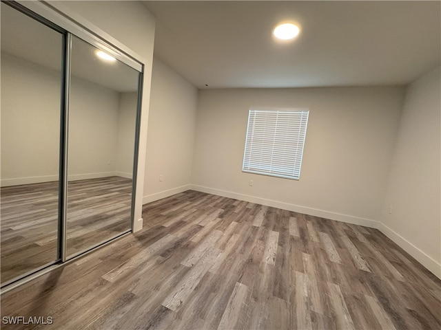 unfurnished bedroom with hardwood / wood-style flooring and a closet