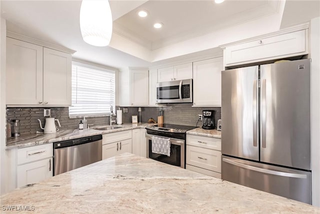 kitchen featuring stainless steel appliances, hanging light fixtures, sink, and white cabinets