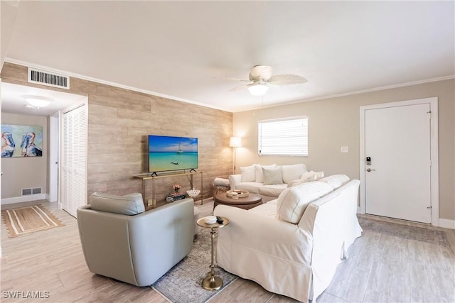 living room with crown molding, ceiling fan, and light hardwood / wood-style floors