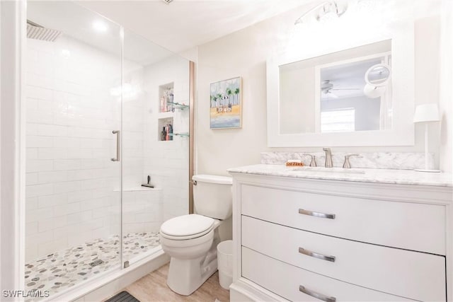 bathroom featuring walk in shower, toilet, vanity, ceiling fan, and hardwood / wood-style floors