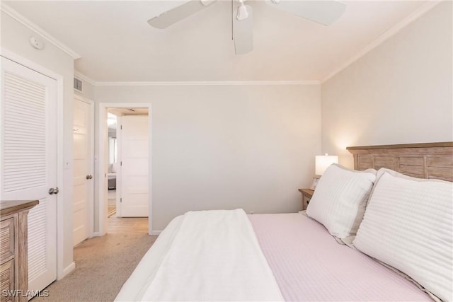 carpeted bedroom with ornamental molding and ceiling fan