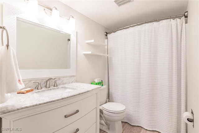 bathroom with vanity, toilet, and hardwood / wood-style floors