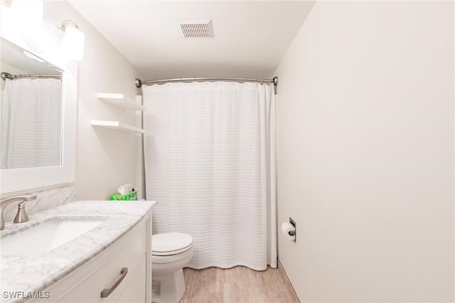 bathroom with vanity, wood-type flooring, and toilet