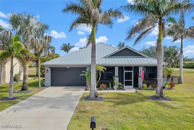 17654 Vellum Cir, Punta Gorda, FL 33955 - view of front of house featuring an attached garage, concrete driveway, a front yard, metal roof, and a sunroom