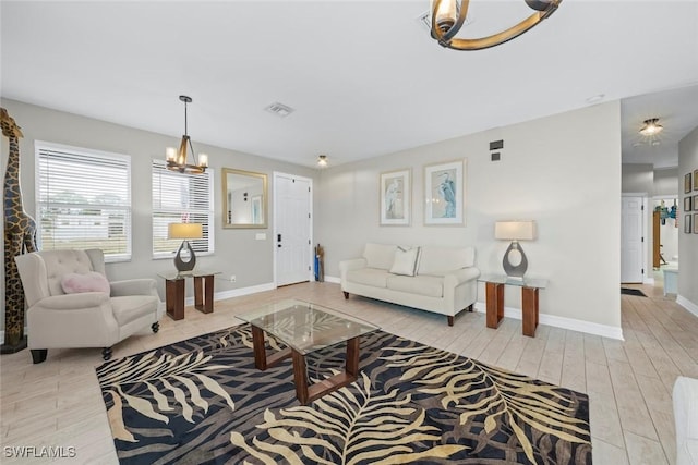 living room with light wood-type flooring and a notable chandelier