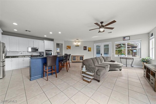 living room featuring light tile patterned floors and ceiling fan