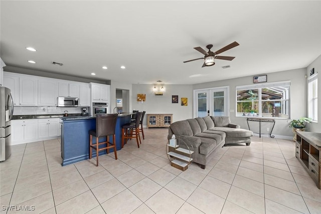 living room with ceiling fan and light tile patterned flooring