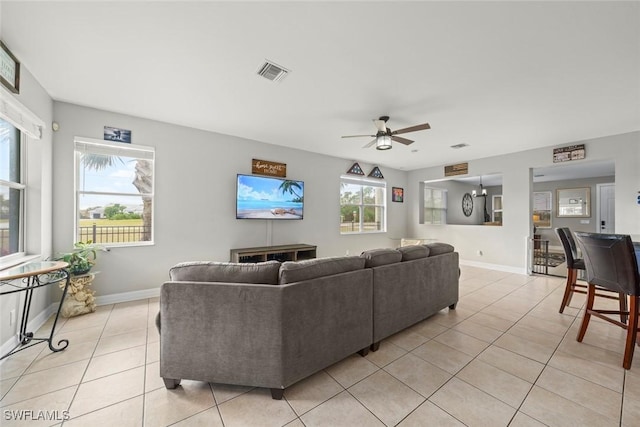 living room with ceiling fan, a wealth of natural light, and light tile patterned floors