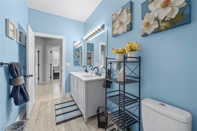 bathroom with hardwood / wood-style flooring, toilet, and vanity