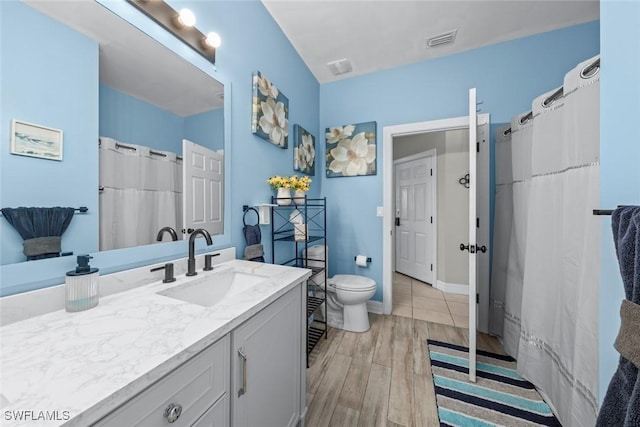 bathroom featuring hardwood / wood-style flooring, toilet, and vanity