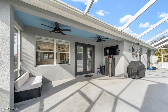 view of patio / terrace with glass enclosure, ceiling fan, french doors, and a grill