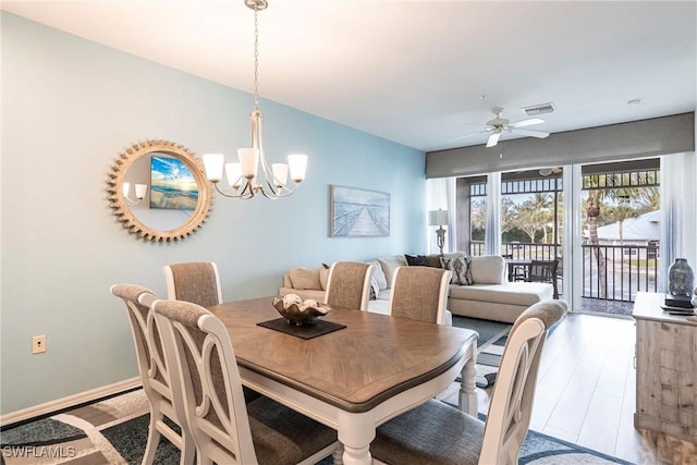 dining space with hardwood / wood-style flooring and ceiling fan with notable chandelier