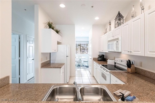 kitchen featuring white cabinetry, sink, white appliances, and light tile patterned flooring