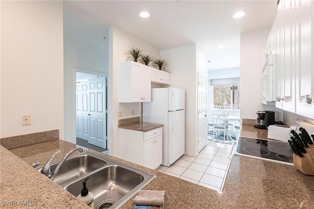 kitchen featuring white appliances, sink, white cabinets, and light tile patterned floors