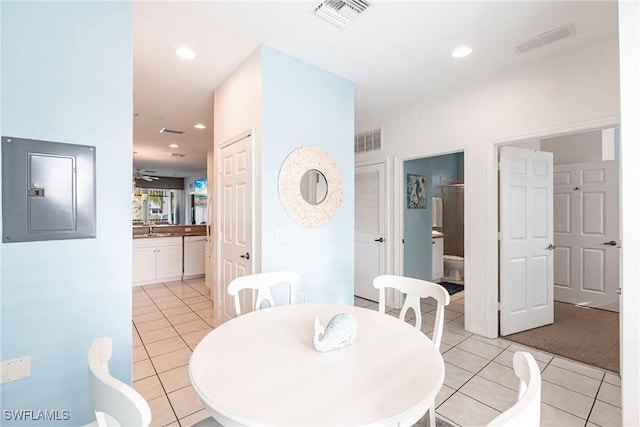 tiled dining room featuring ceiling fan, sink, and electric panel